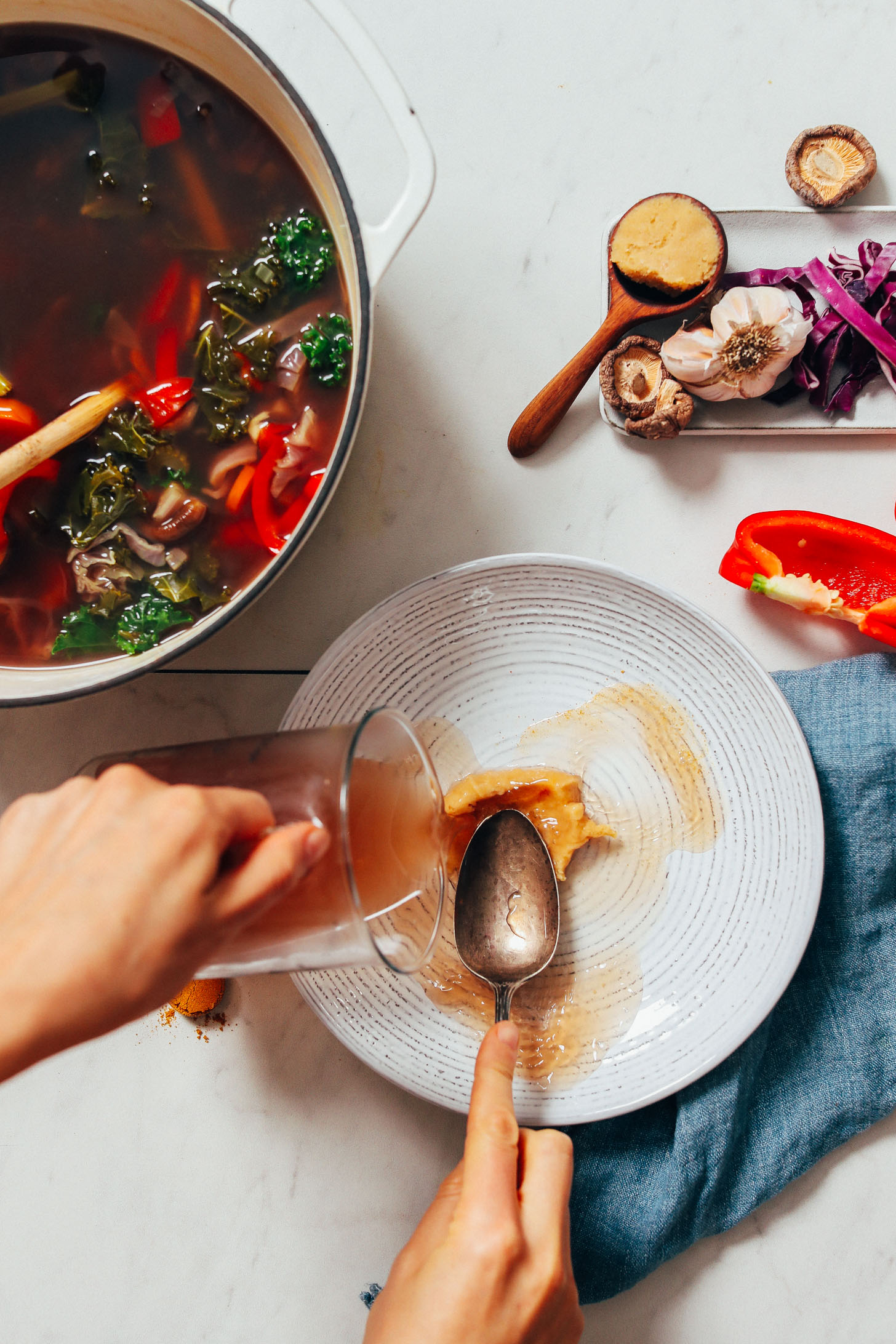 Mixing vegetable broth and miso in a bowl