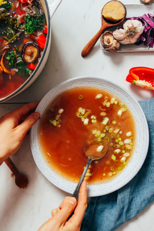 Holding a spoon in a bowl of Gut-Calming Vegetable Broth
