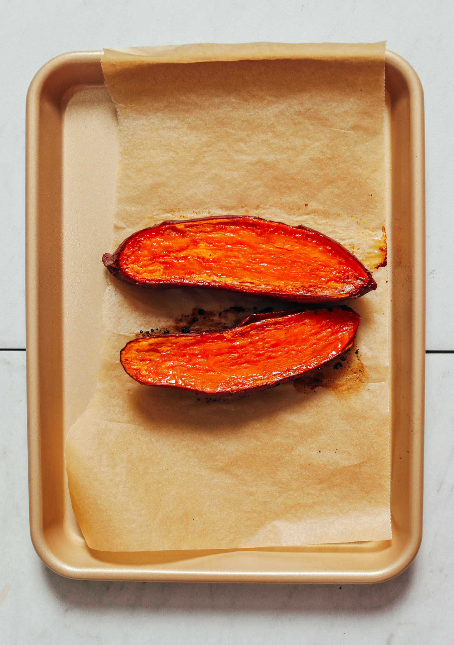 Baking sheet with a halved roasted sweet potato