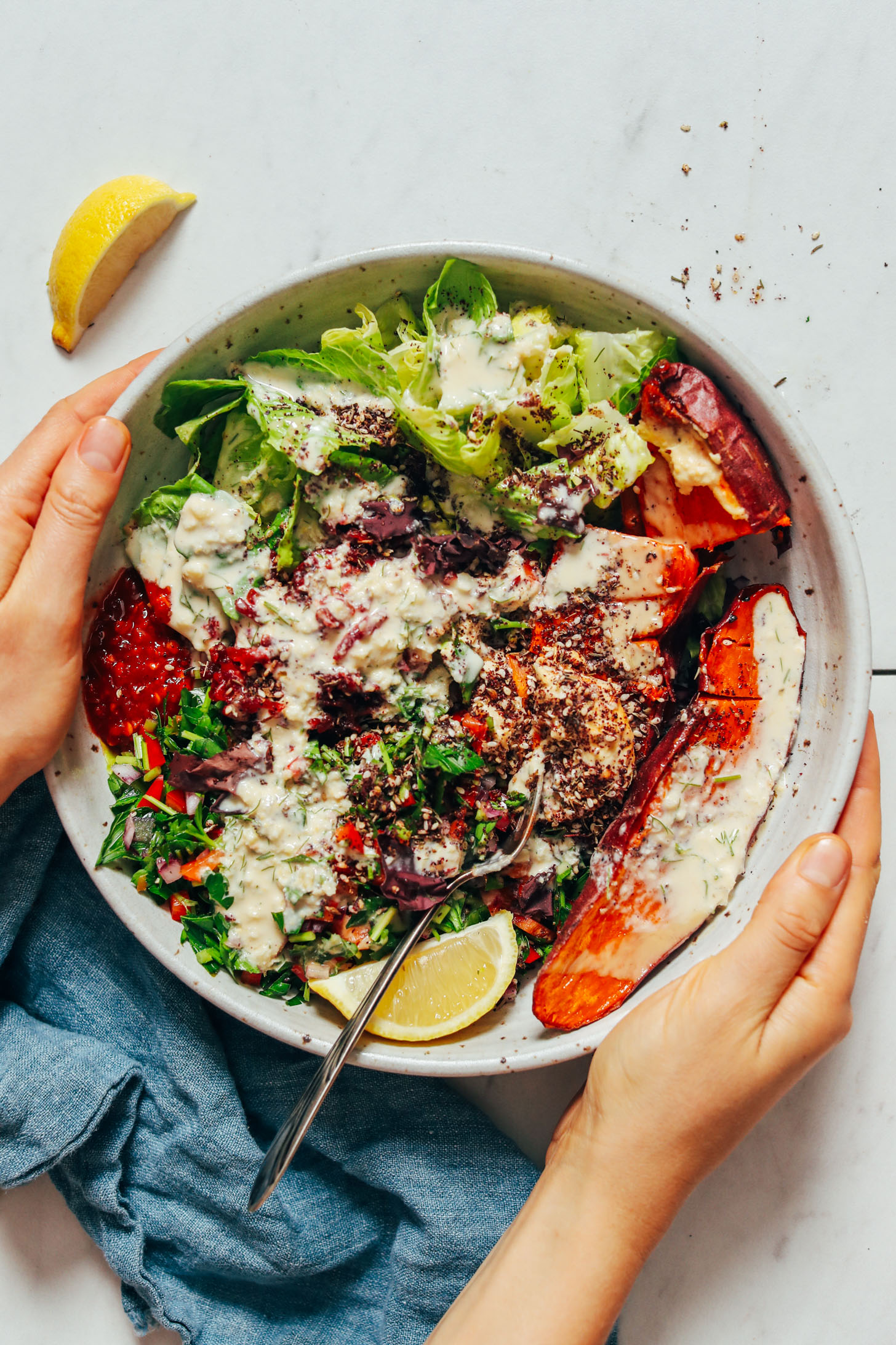 Holding the sides of a nourishing bowl meal inspired by Middle Eastern and Mediterranean cuisine