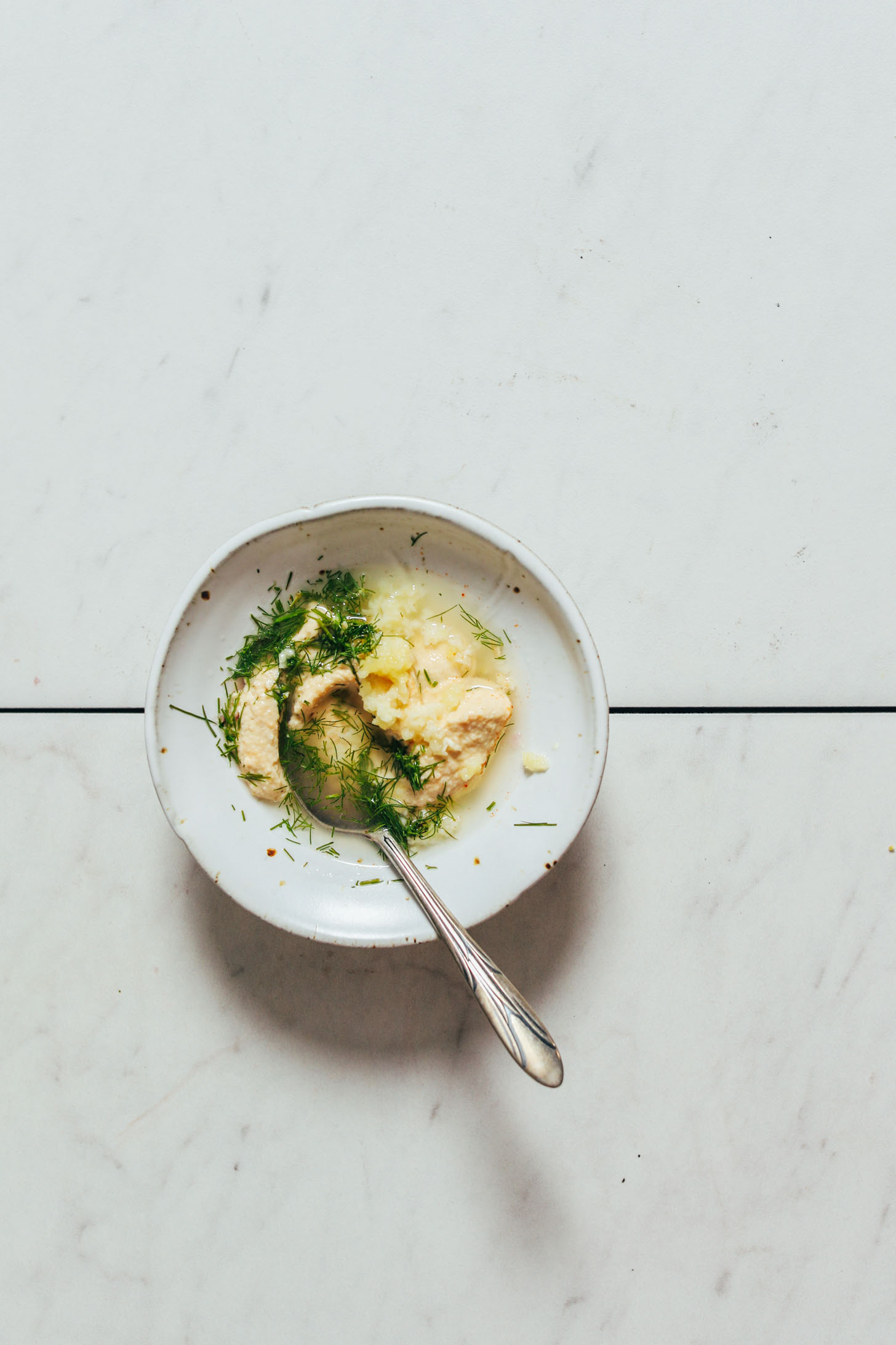 Bowl of hummus, dill, garlic, and lemon