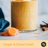 Sprinkling shredded coconut onto a Vegan Carrot Smoothie