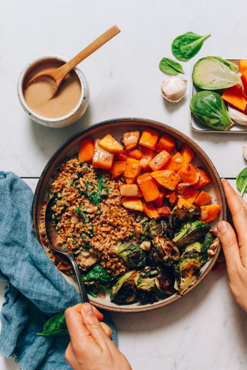 Butternut Squash & Miso Brussels Sprouts Bowl next to a bowl of tahini sauce