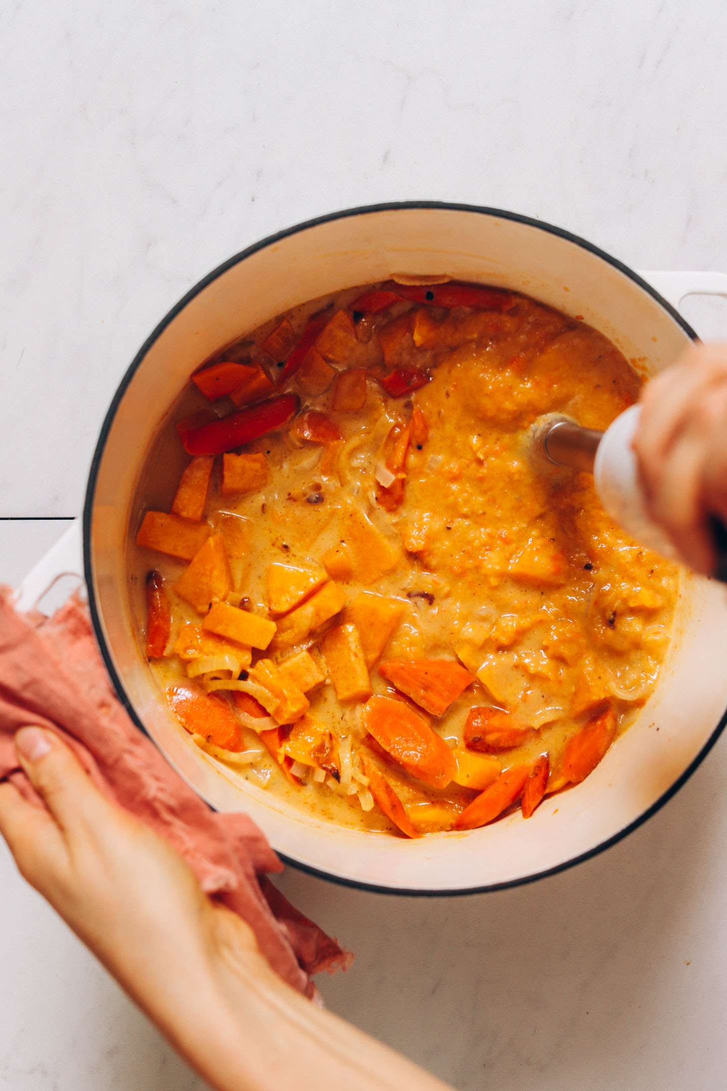 Using an immersion blender to purée a pot of roasted butternut squash soup