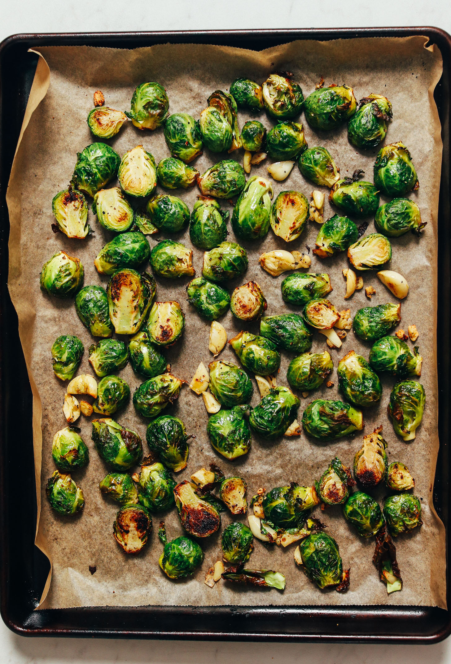 Parchment-lined baking sheet of roasted Brussels sprouts