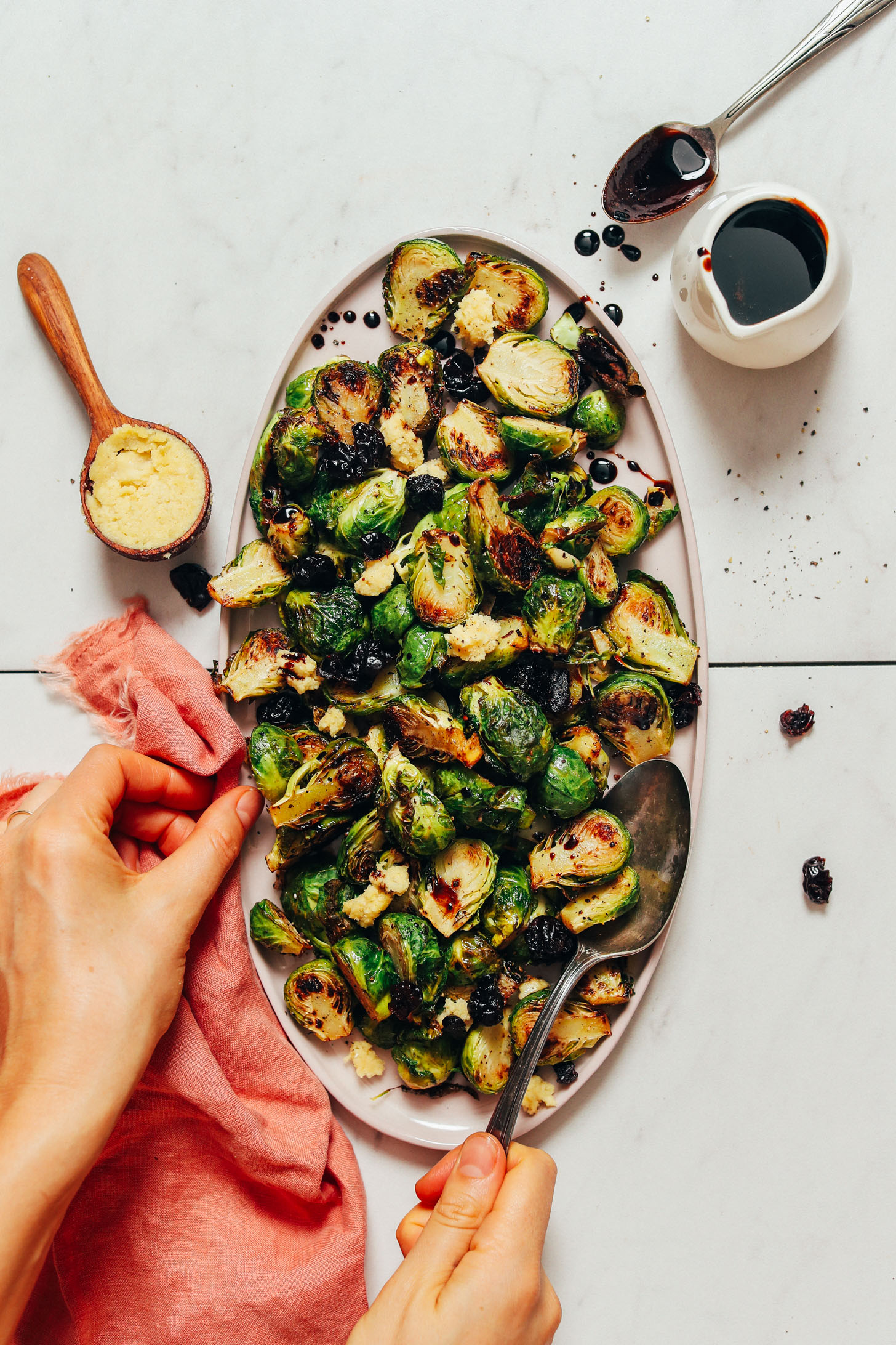 Platter of Crispy Roasted Brussels Sprouts with dried cherries, balsamic reduction, and vegan cheese