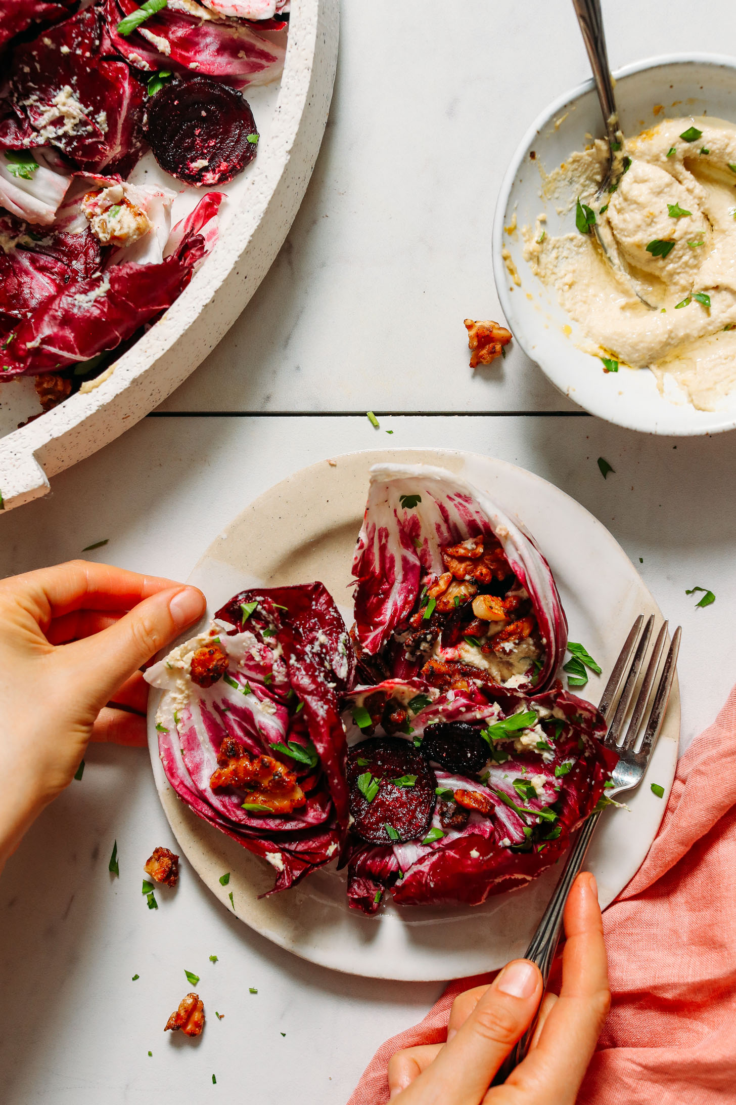 Plate of radicchio salad next to a bowl of cashew ricotta dressing