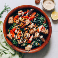 Tahini sauce next to a large bowl of Rosemary Roasted Root Vegetable Panzanella