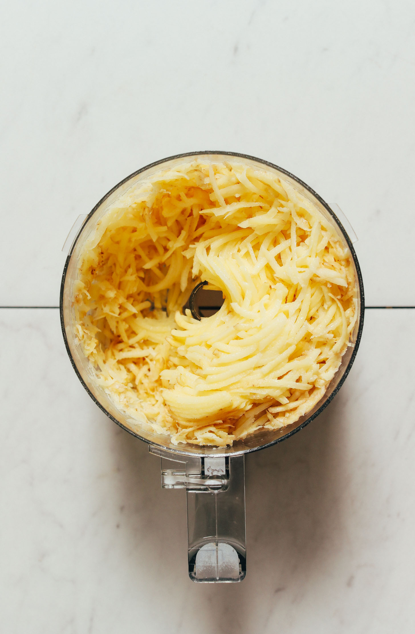 Shredded potatoes in a food processor