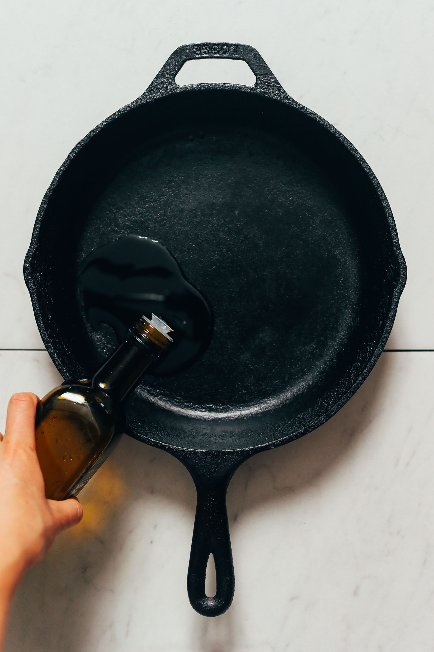 Pouring oil into a cast iron skillet