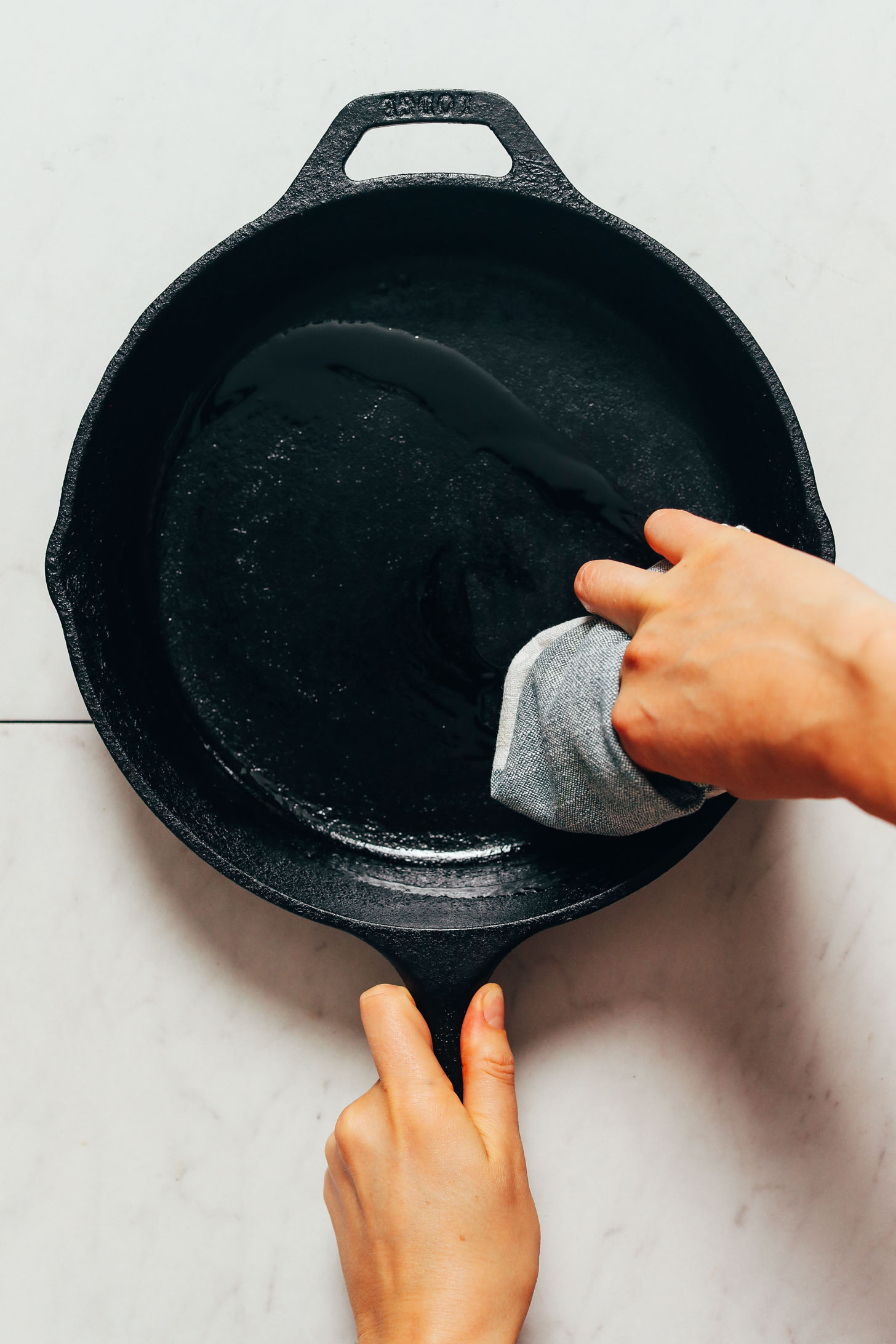 Spreading oil in a cast iron skillet to season it