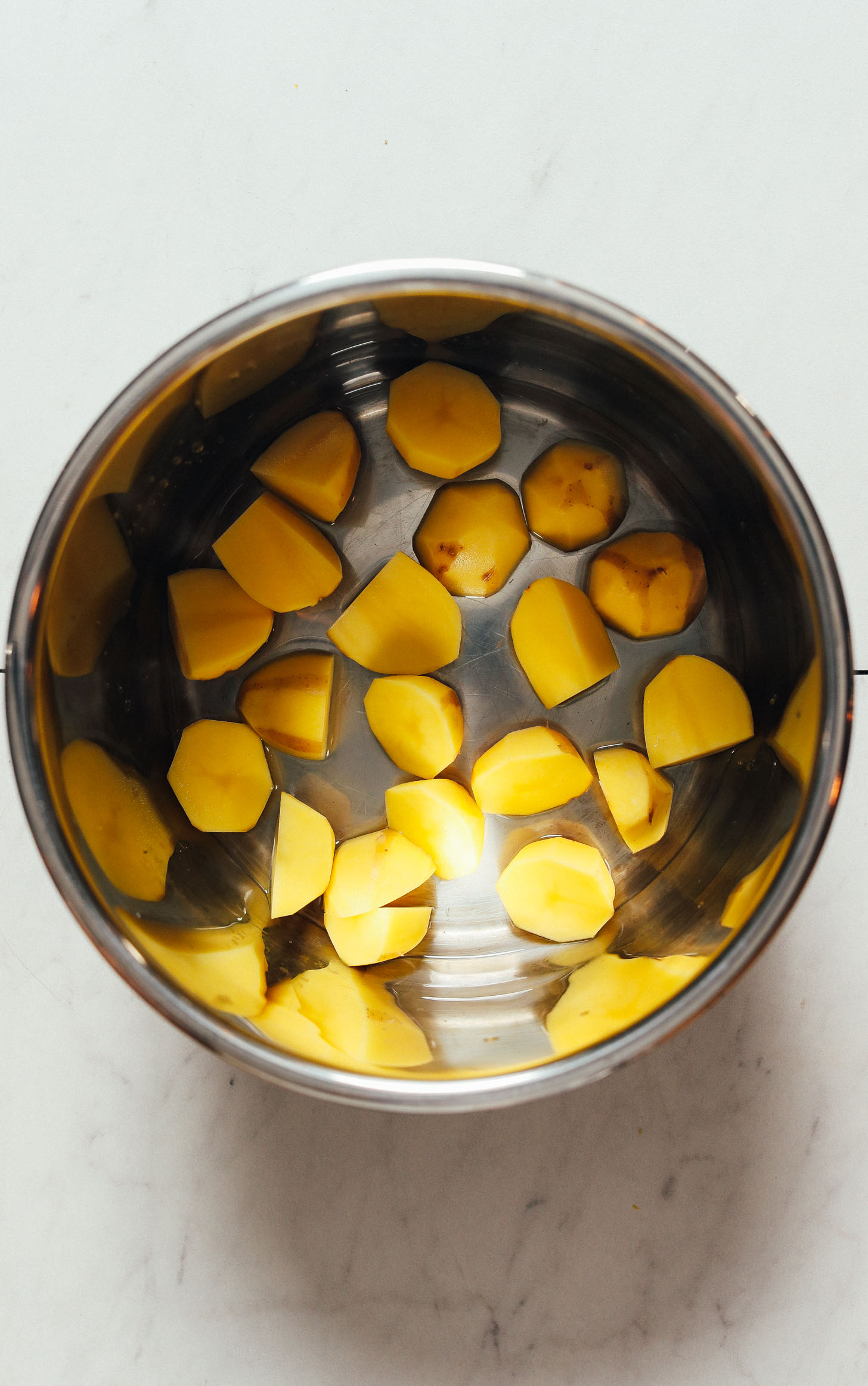 Partially peeled and chopped potatoes in an Instant Pot