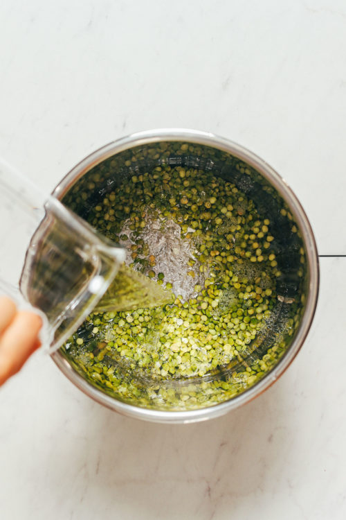 Pouring water into an Instant Pot of green split peas