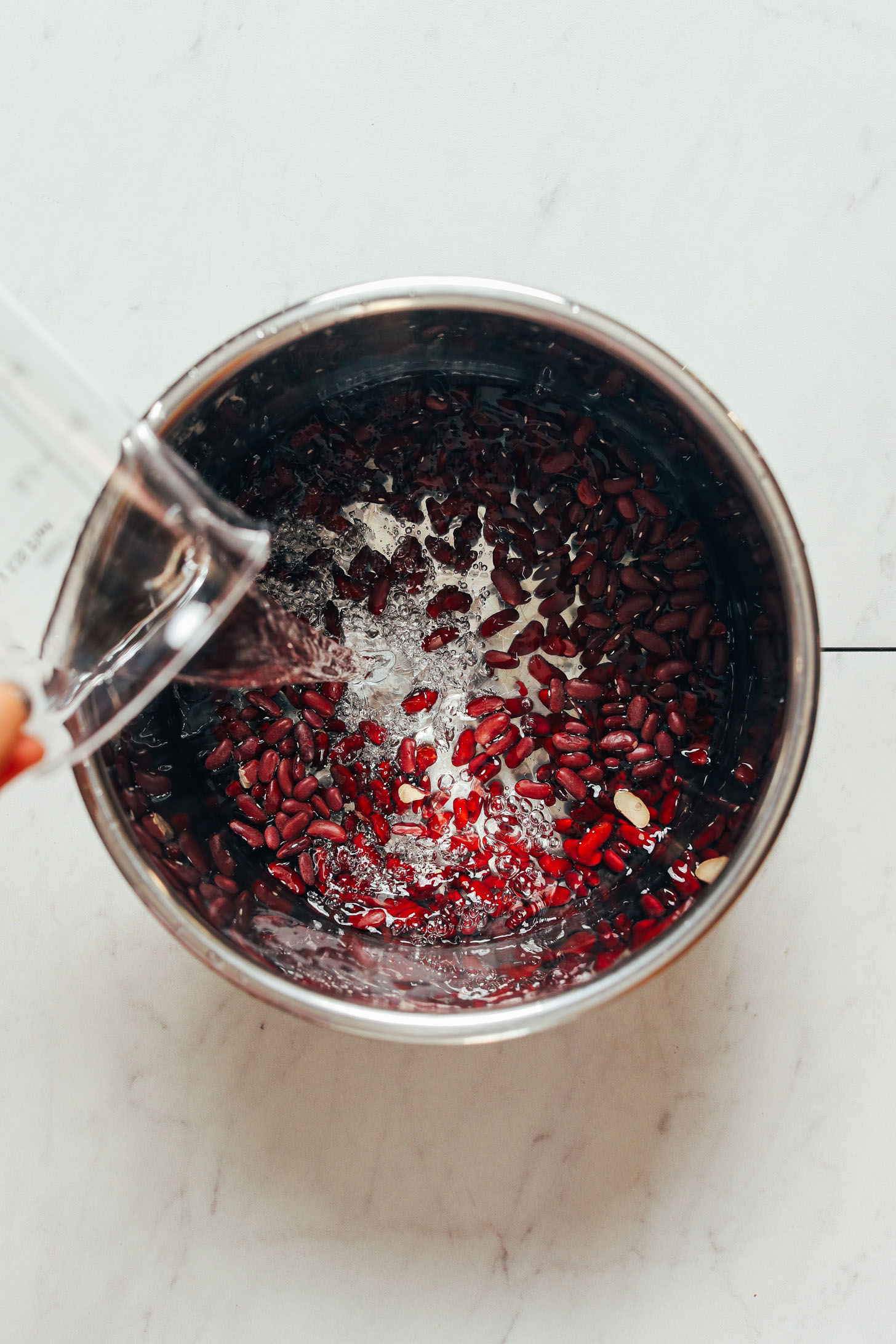 Pouring water into an Instant Pot of dried kidney beans