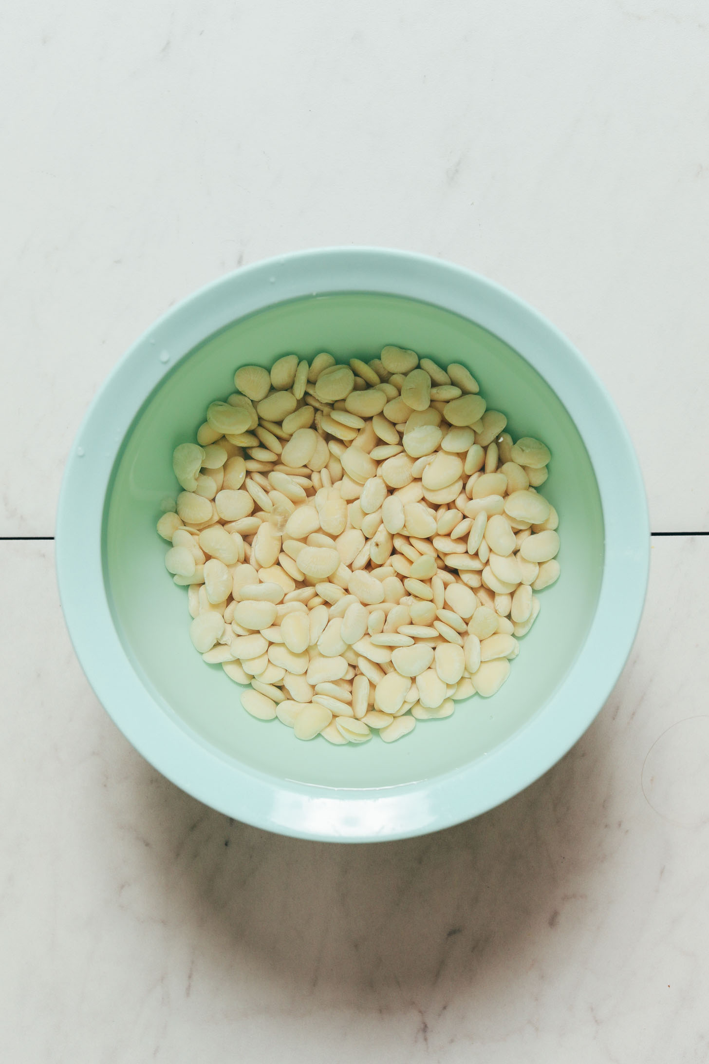 Soaking baby lima beans in water to make them perfectly tender