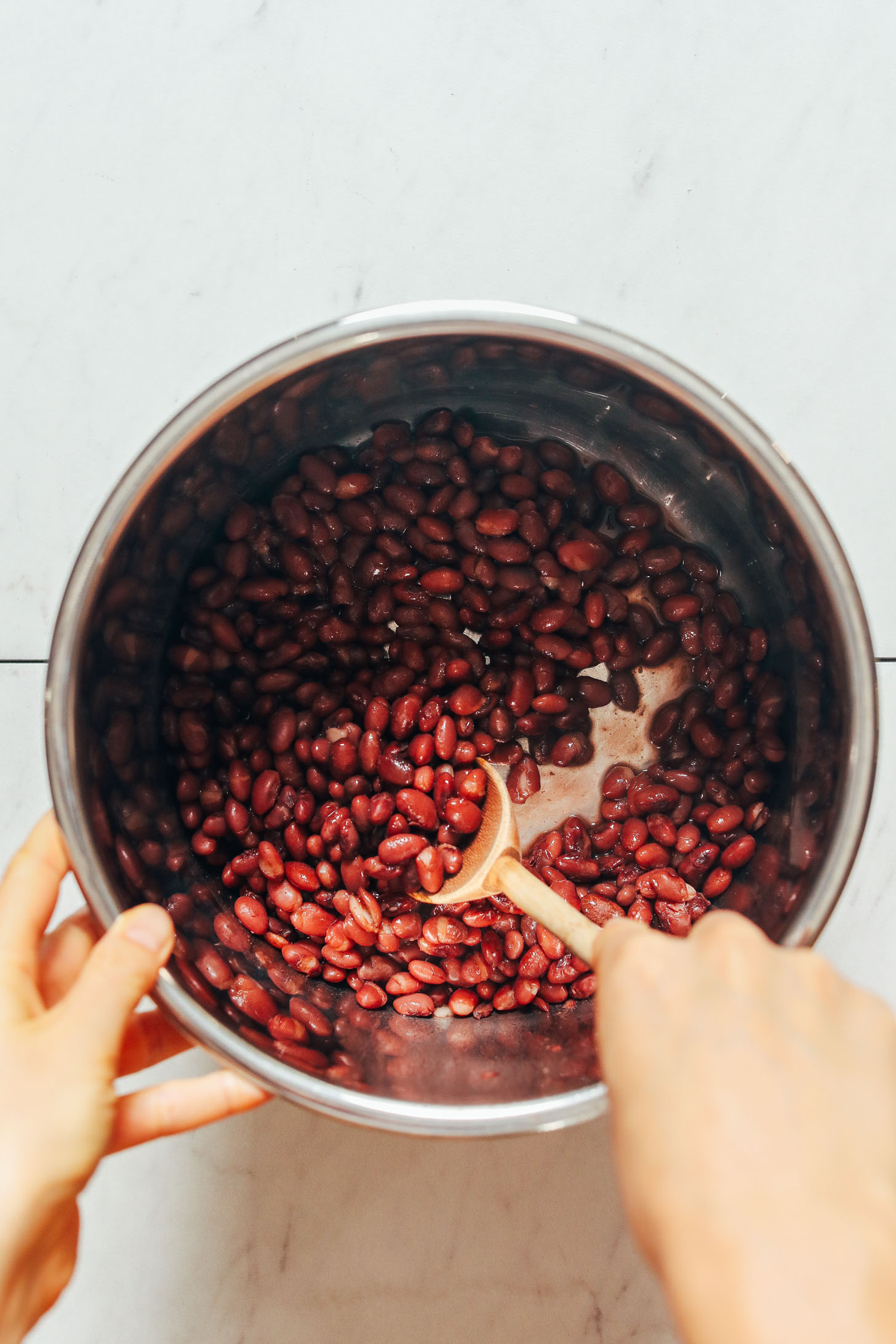 Using a wooden spoon to stir red beans in the Instant Pot