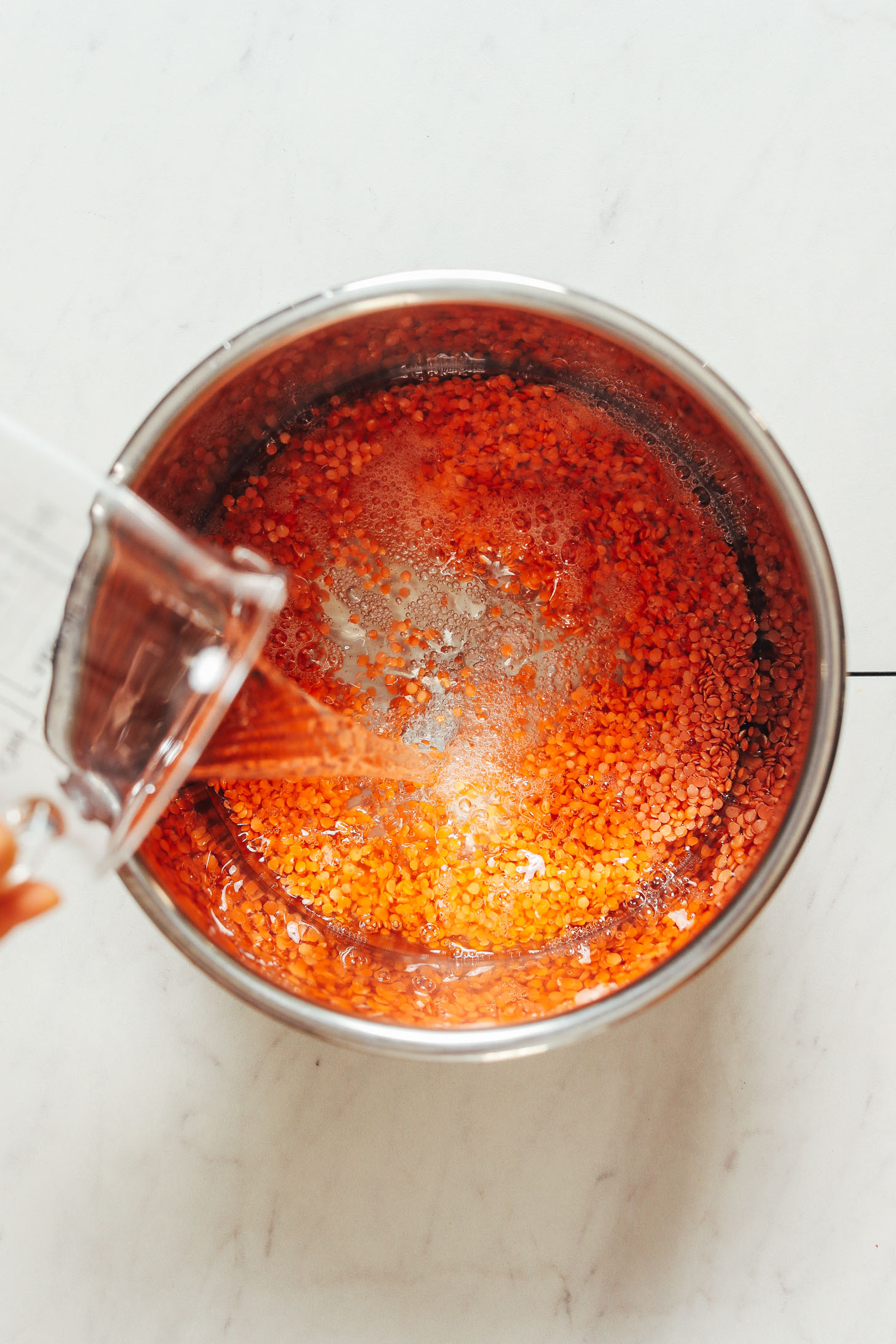 Pouring water over dry red lentils