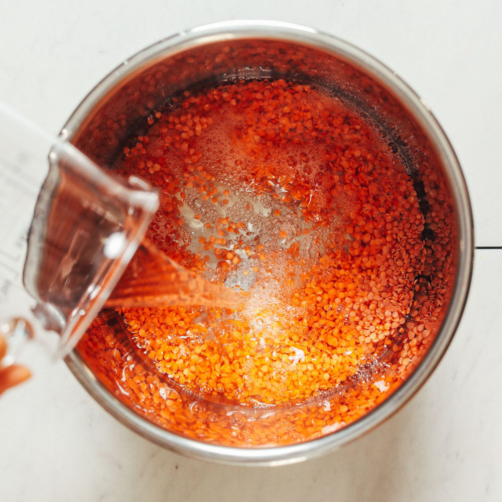Pouring water over red lentils