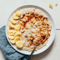 Bowl of Instant Pot oats topped with sliced banana, brown sugar, and pecans