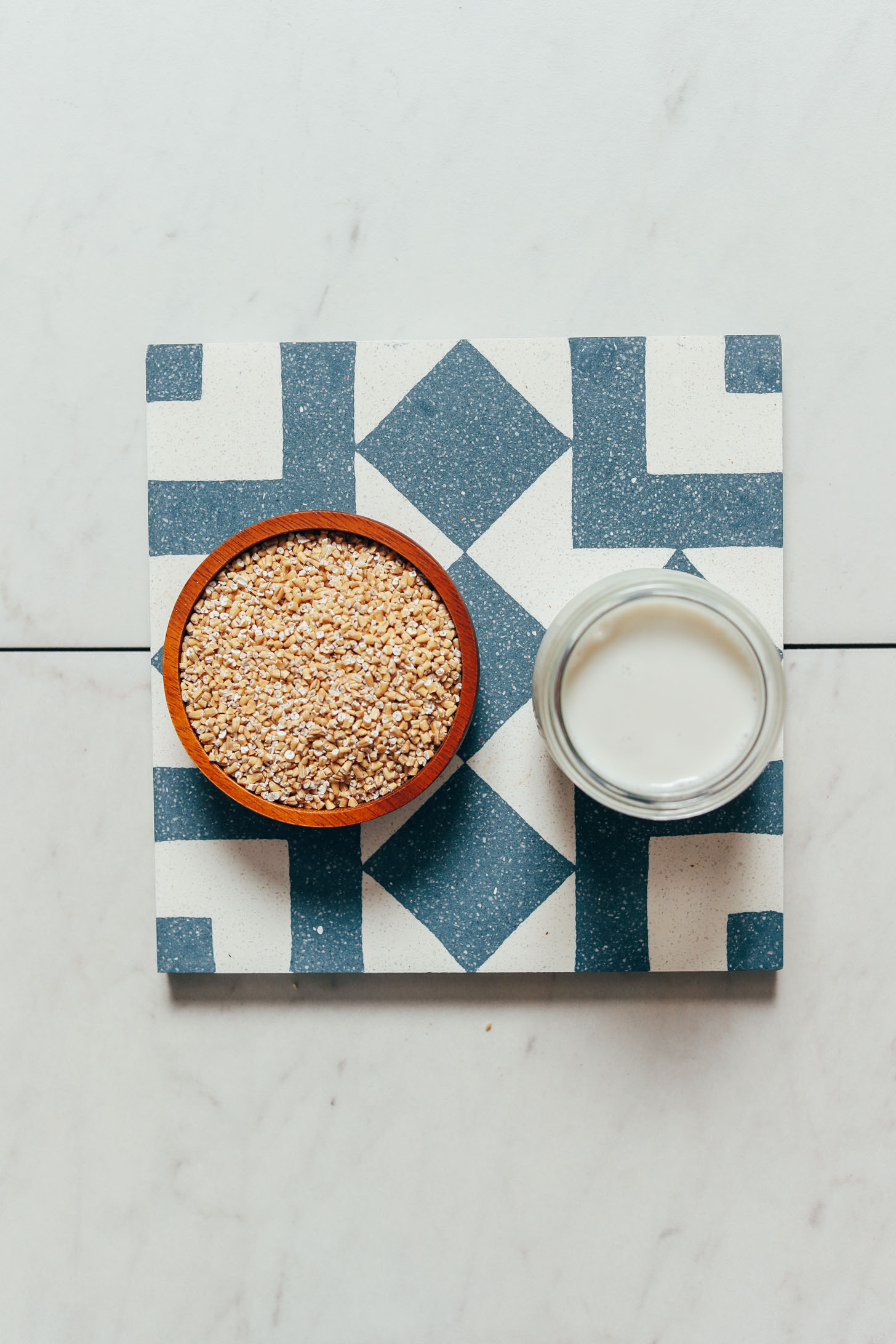 Bowl of steel cut oats and jar of dairy-free milk