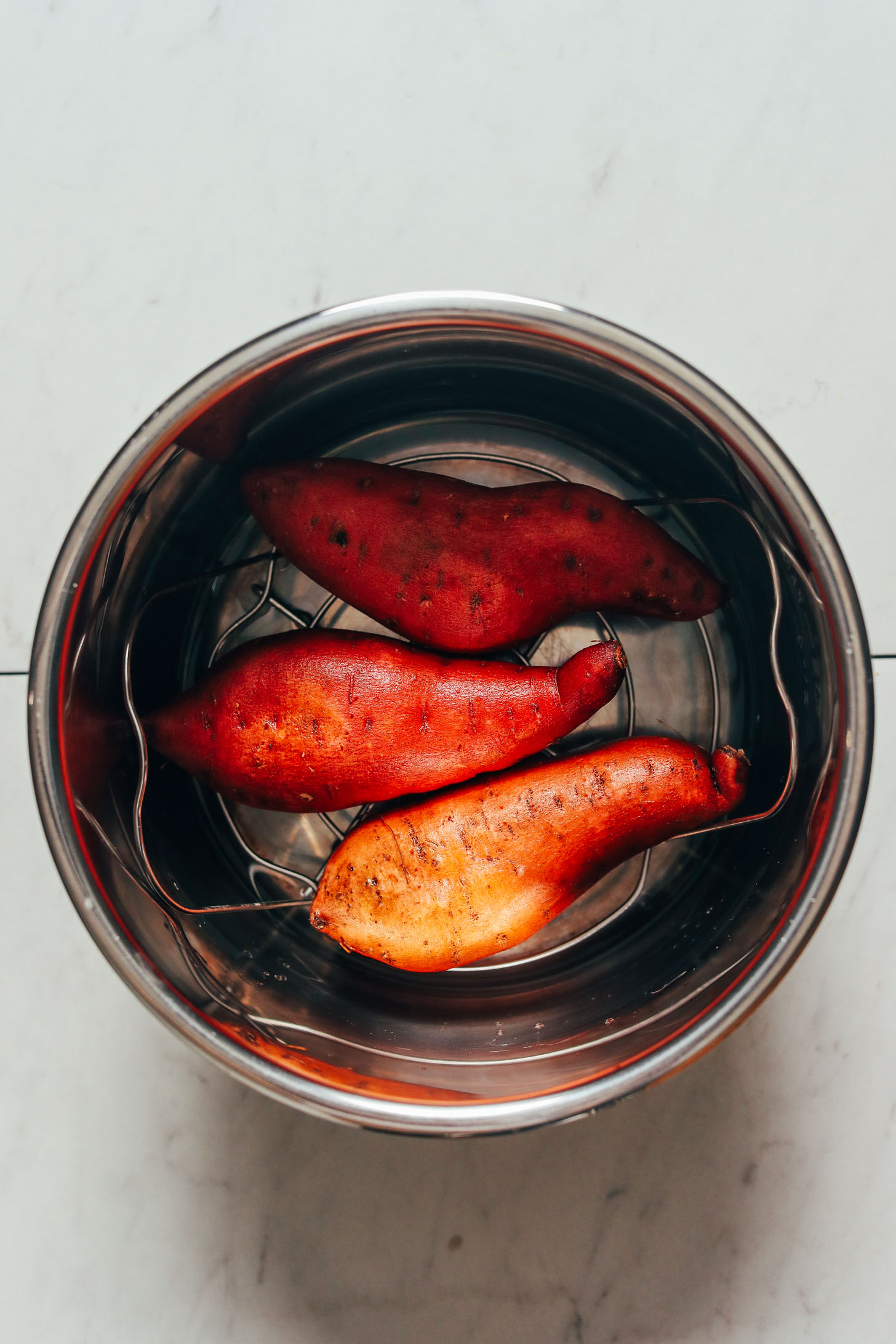 Sweet potatoes on a trivet in an Instant Pot before cooking