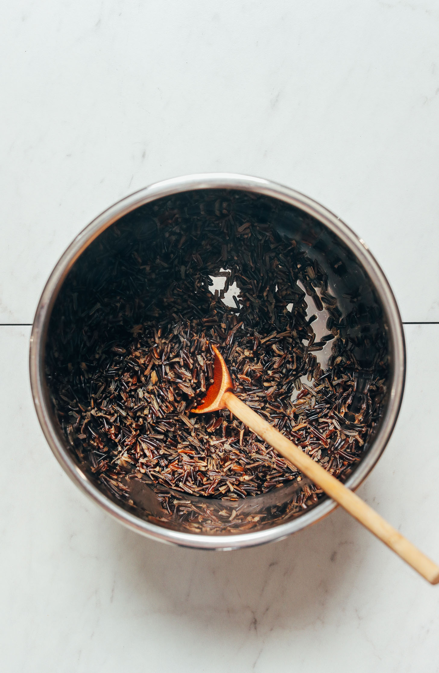 Wooden spoon in an Instant Pot of wild rice
