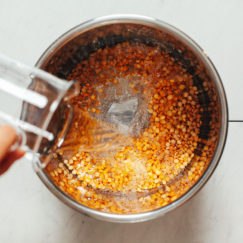 Pouring water into an Instant Pot of yellow split peas