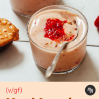Spoonful of peanut butter next to two glasses of our PB&J Smoothie