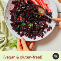 Stirring a bowl of cubed roasted beets with cumin, lime, and cilantro