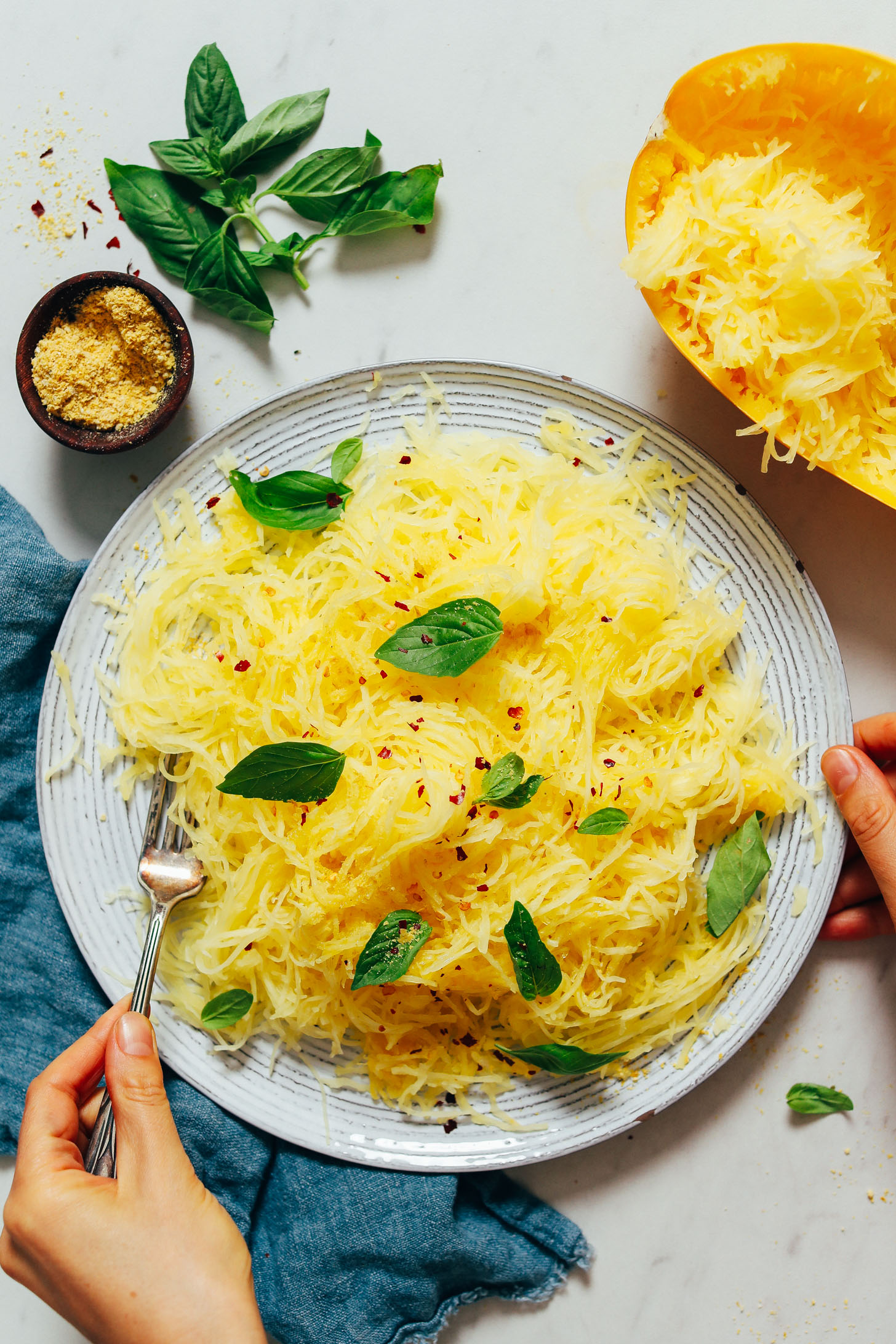 Bowl of spaghetti squash topped with fresh basil and red chili flakes