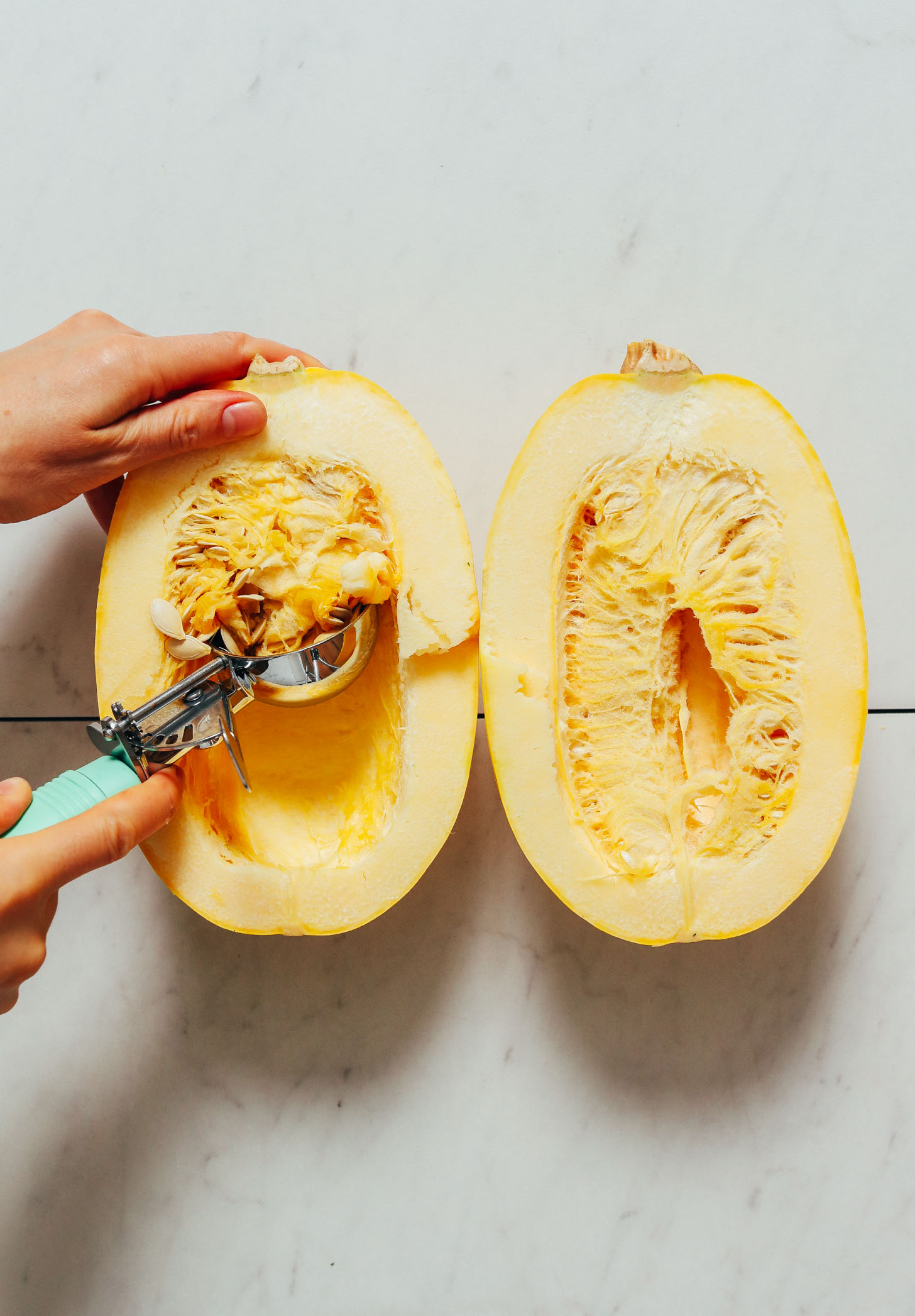 Scooping seeds from a spaghetti squash