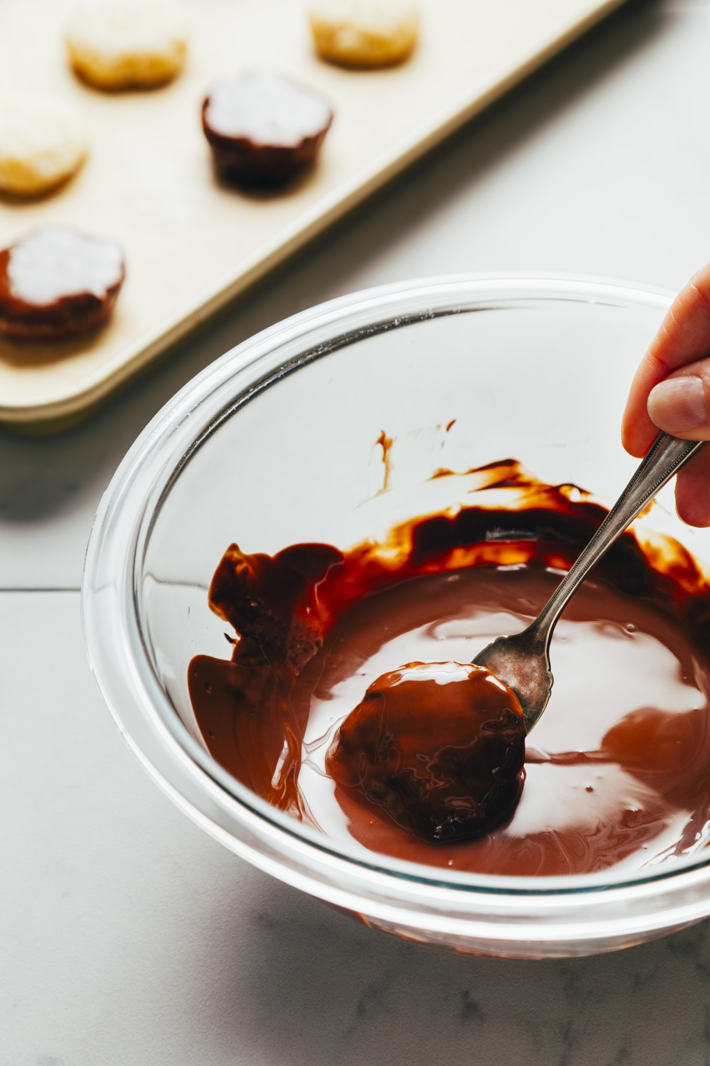 Dipping coconut peppermint discs in melted chocolate