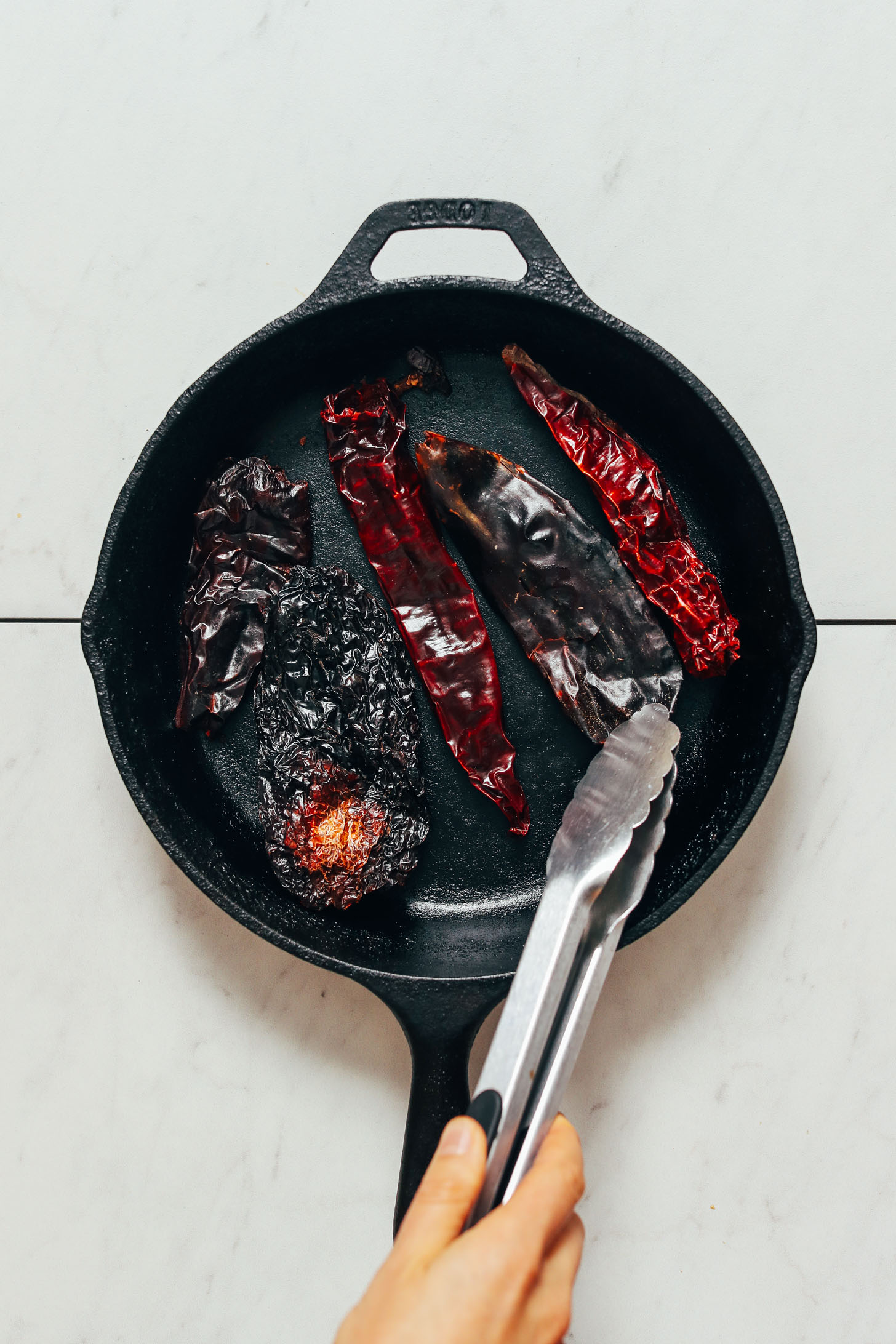 Toasting dried chilies in a cast iron skillet