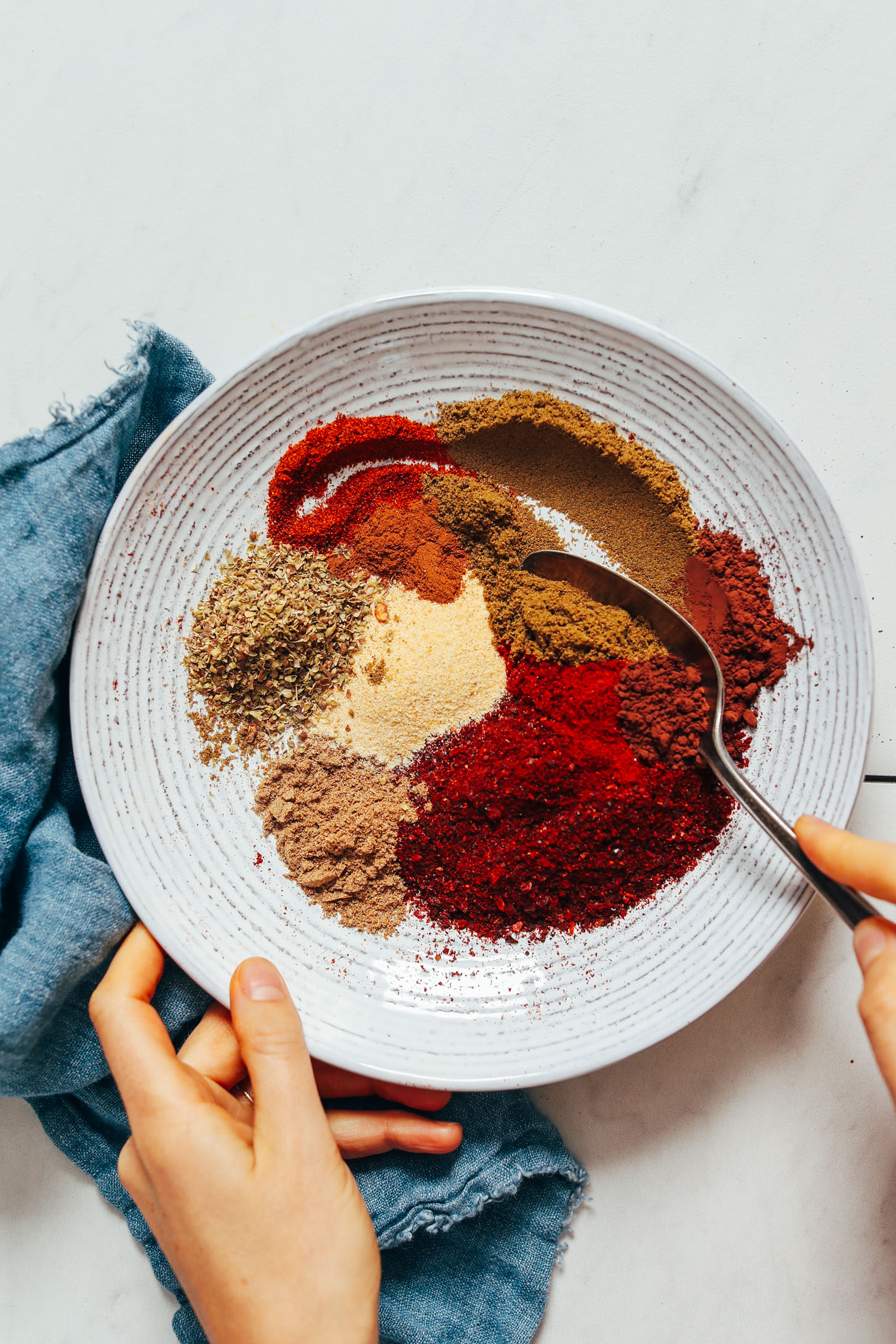 Bowl of toasted ground chilies, oregano, cumin, garlic powder, smoked paprika, cayenne, cocoa powder, and cinnamon