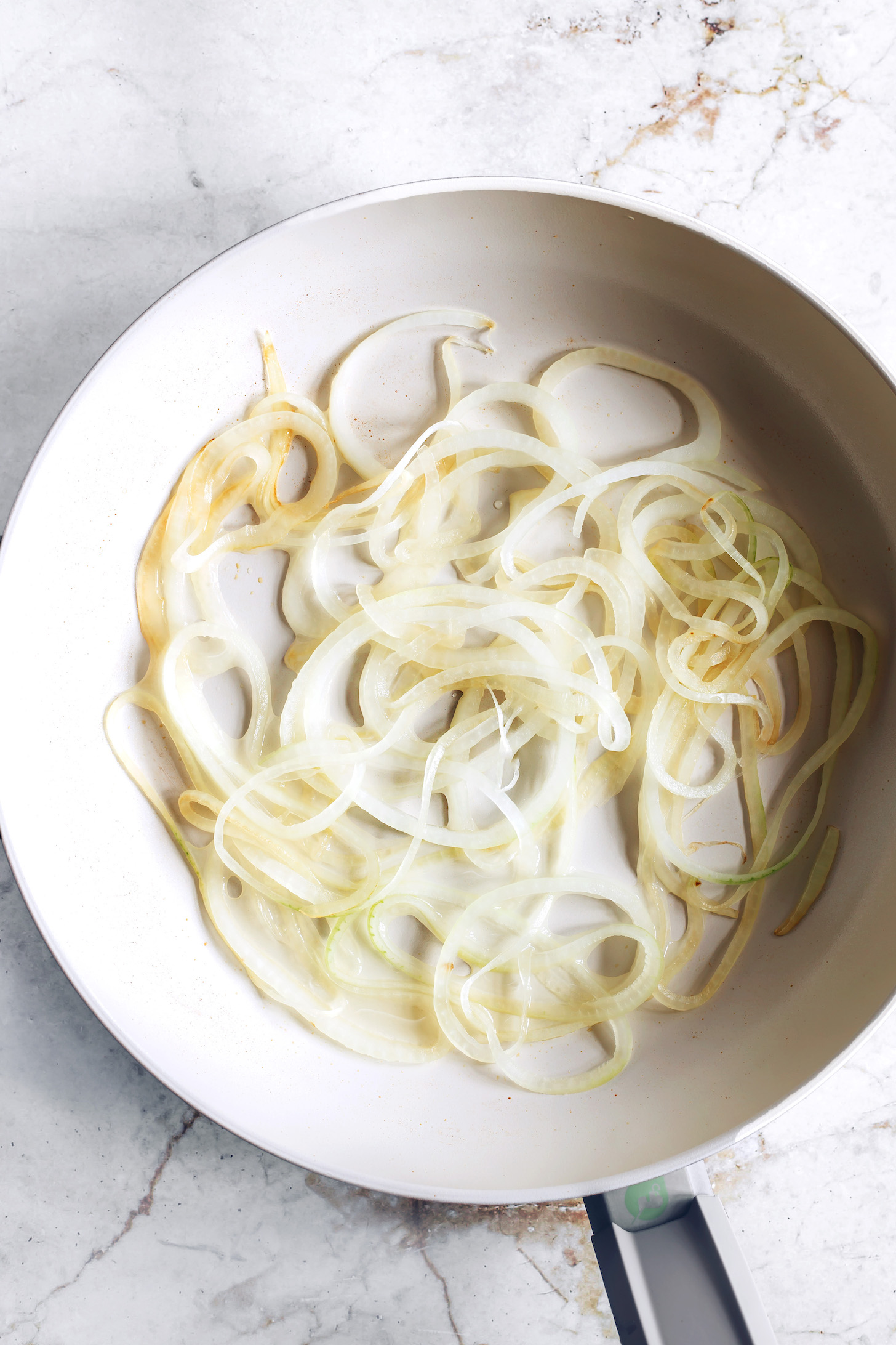 Thinly sliced onions in a non-stick pan