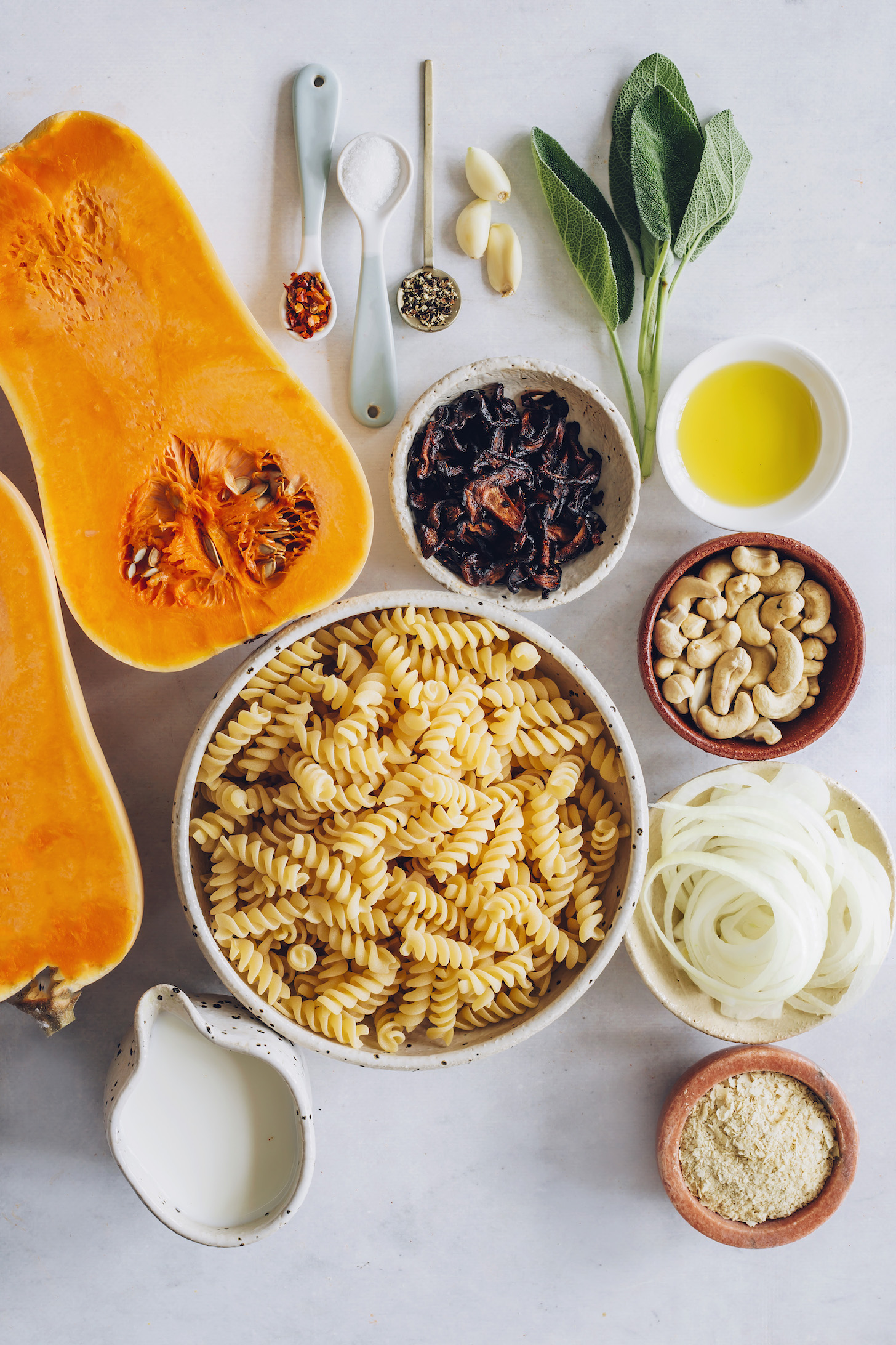 Butternut squash, GF pasta, cashews, nutritional yeast, onions, almond milk, cashews, shiitake bacon, bay leaf, olive oil, garlic, salt, pepper, and chili flakes