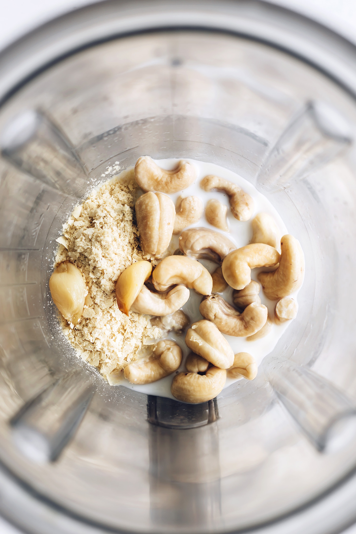 Blender with almond milk, roasted garlic, and nutritional yeast
