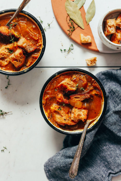 Bowls of vegan french onion soup topped with jumbo croutons