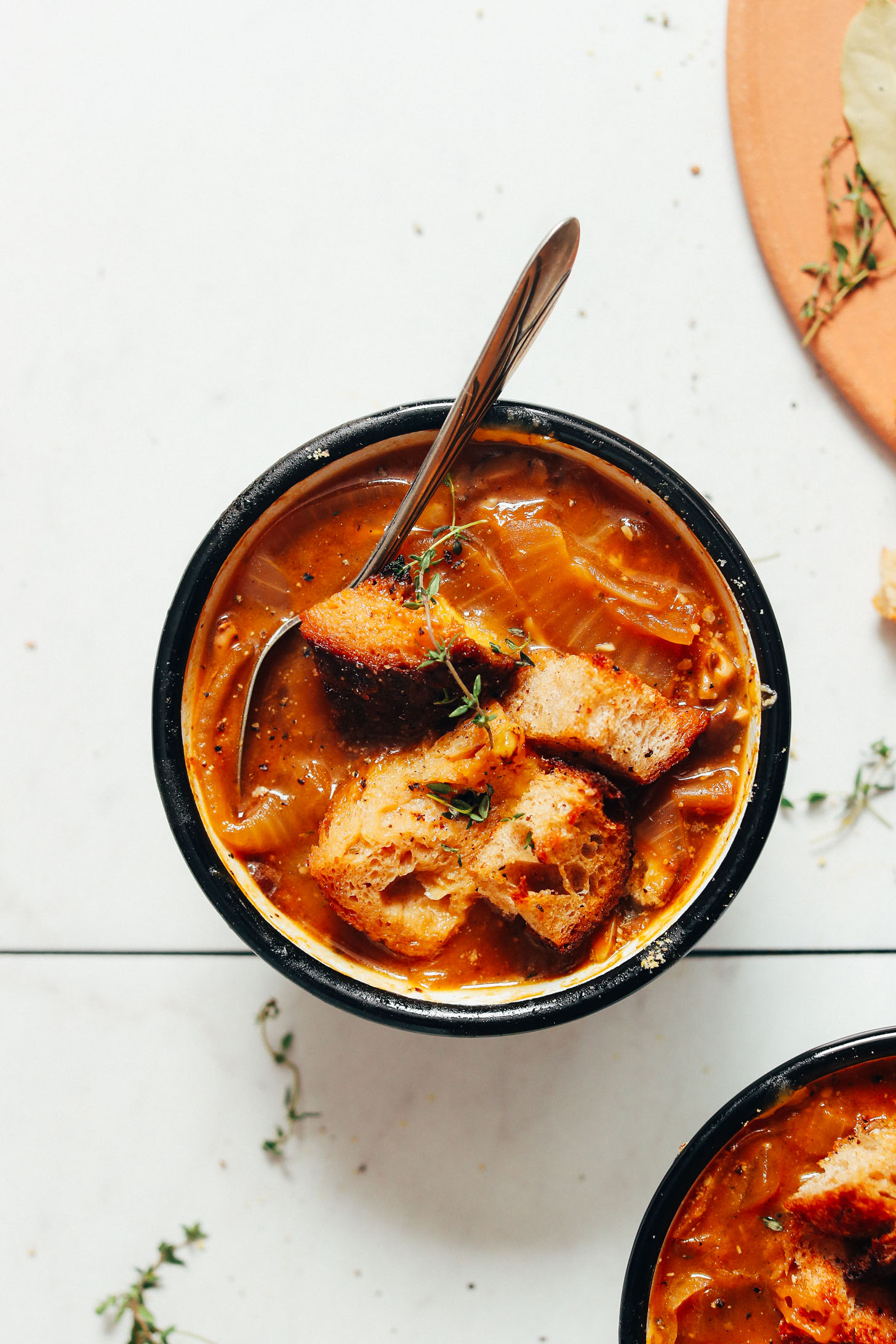 Fresh thyme sprig on a bowl of vegan french onion soup