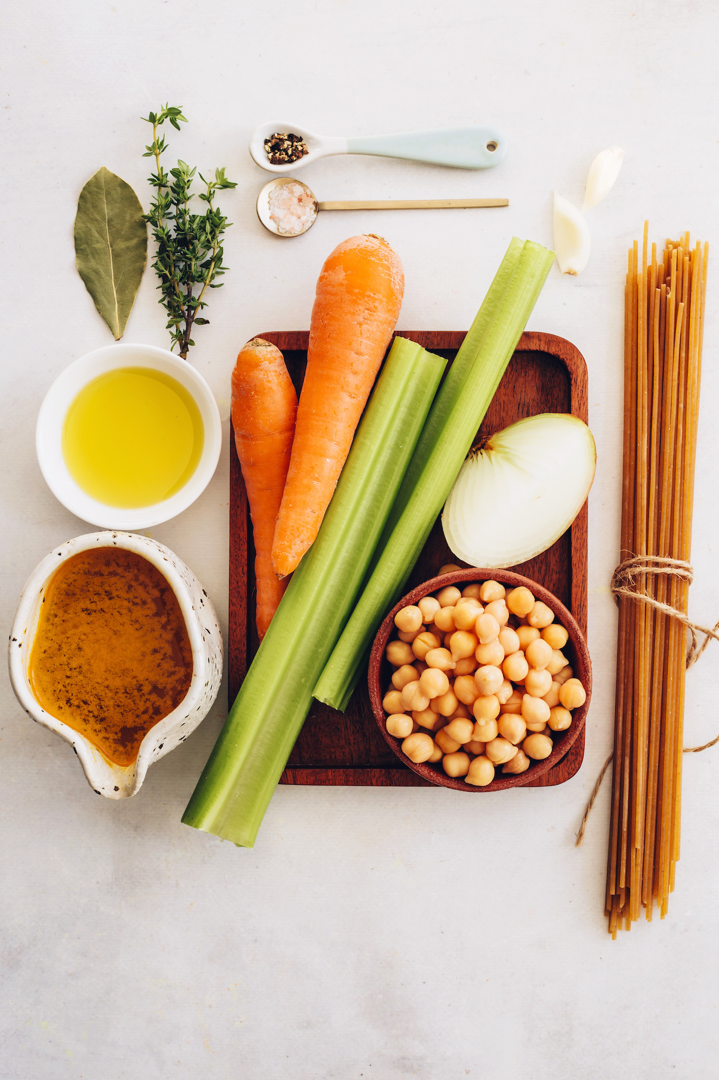Bay leaf, fresh thyme, salt, pepper, garlic, onion, celery, carrot, olive oil, vegetable broth, chickpeas, and noodles