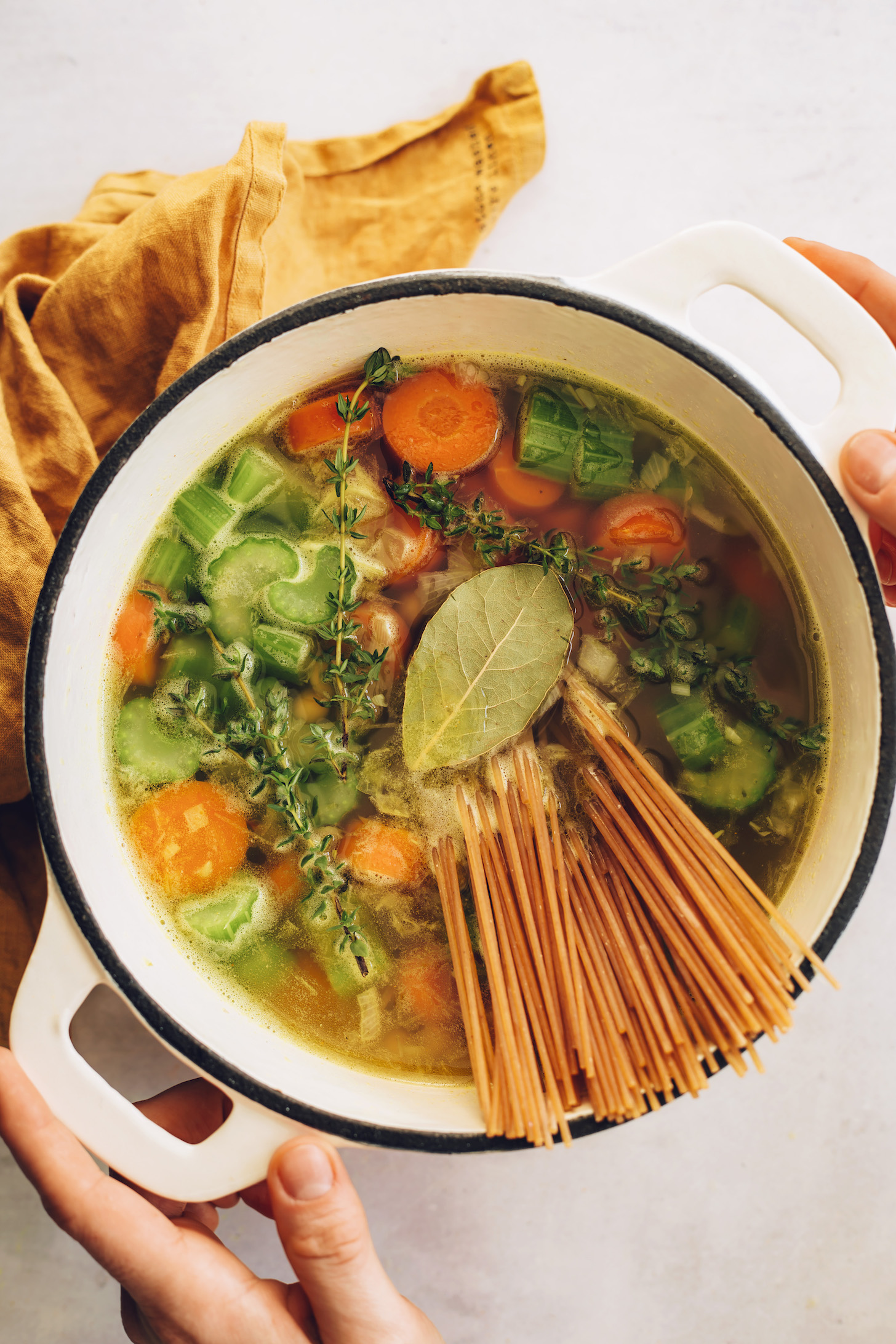 Gluten-free noodles sticking out of a pot of vegan chicken noodle soup