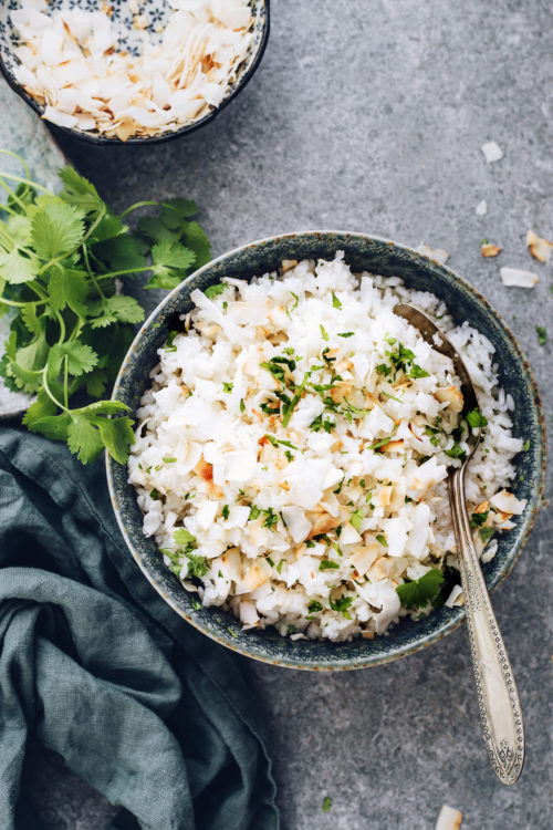 Bowl of easy coconut rice topped with cilantro and toasted coconut flakes