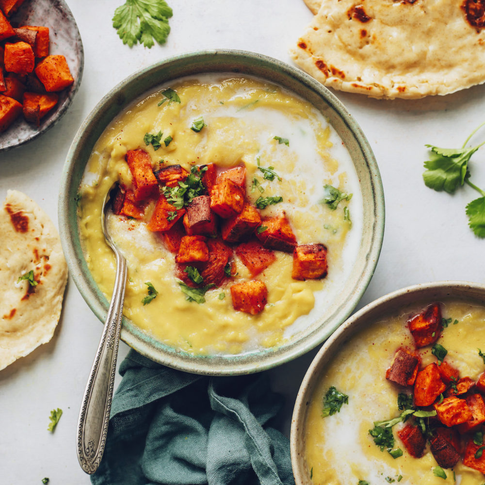 Bowls of yellow split pea soup topped with roasted sweet potato
