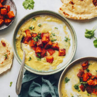 Bowls of yellow split pea soup topped with roasted sweet potato