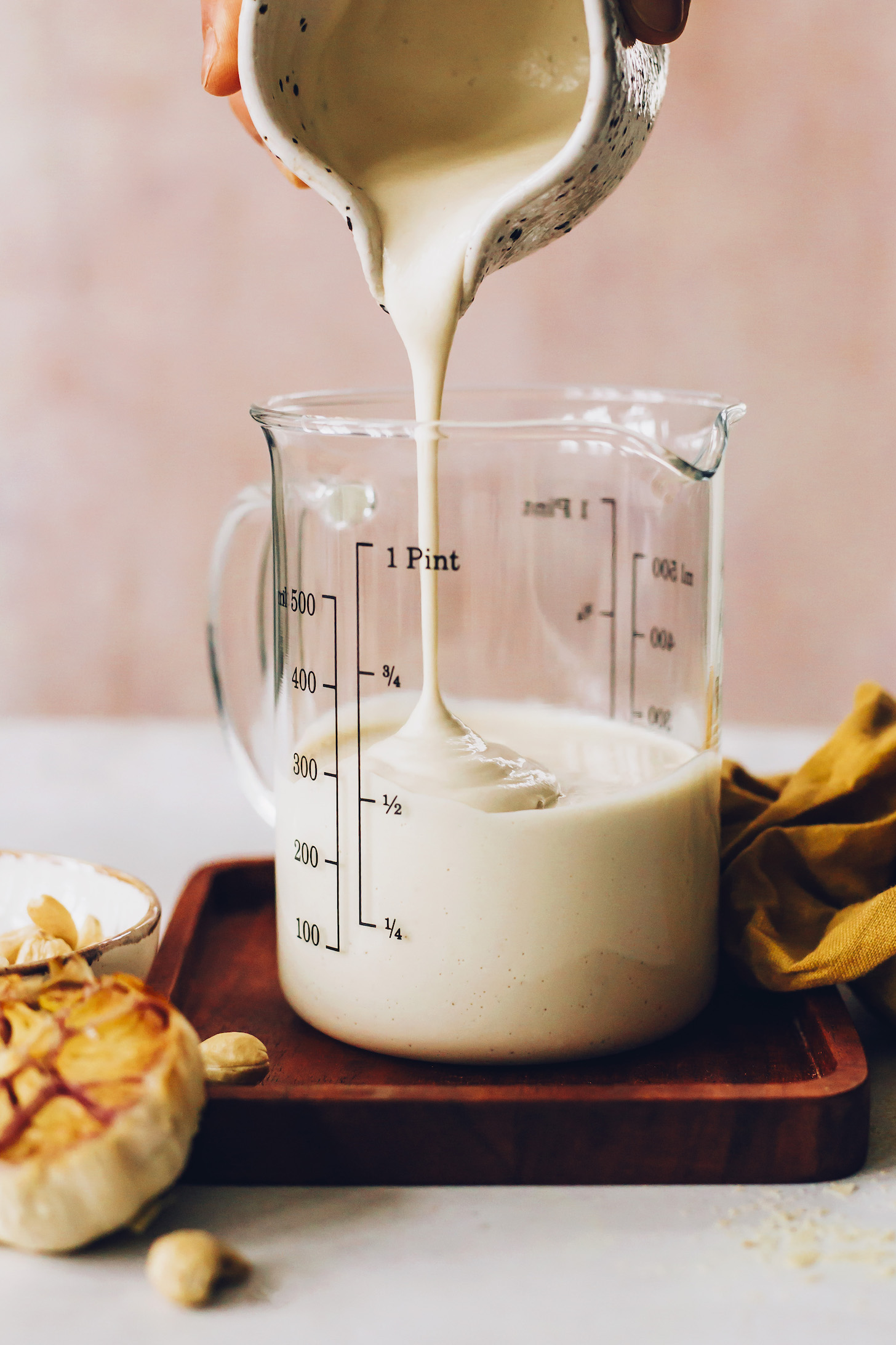 Pouring vegan bechamel sauce into a beaker