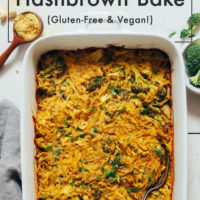 Spoonful of nutritional yeast beside a pan of our Cheesy Hashbrown Bake