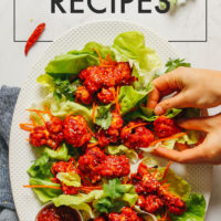 Picking up spicy cauliflower wings from a platter