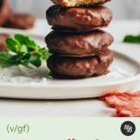 Stack of homemade peppermint patties next to shredded coconut and fresh mint