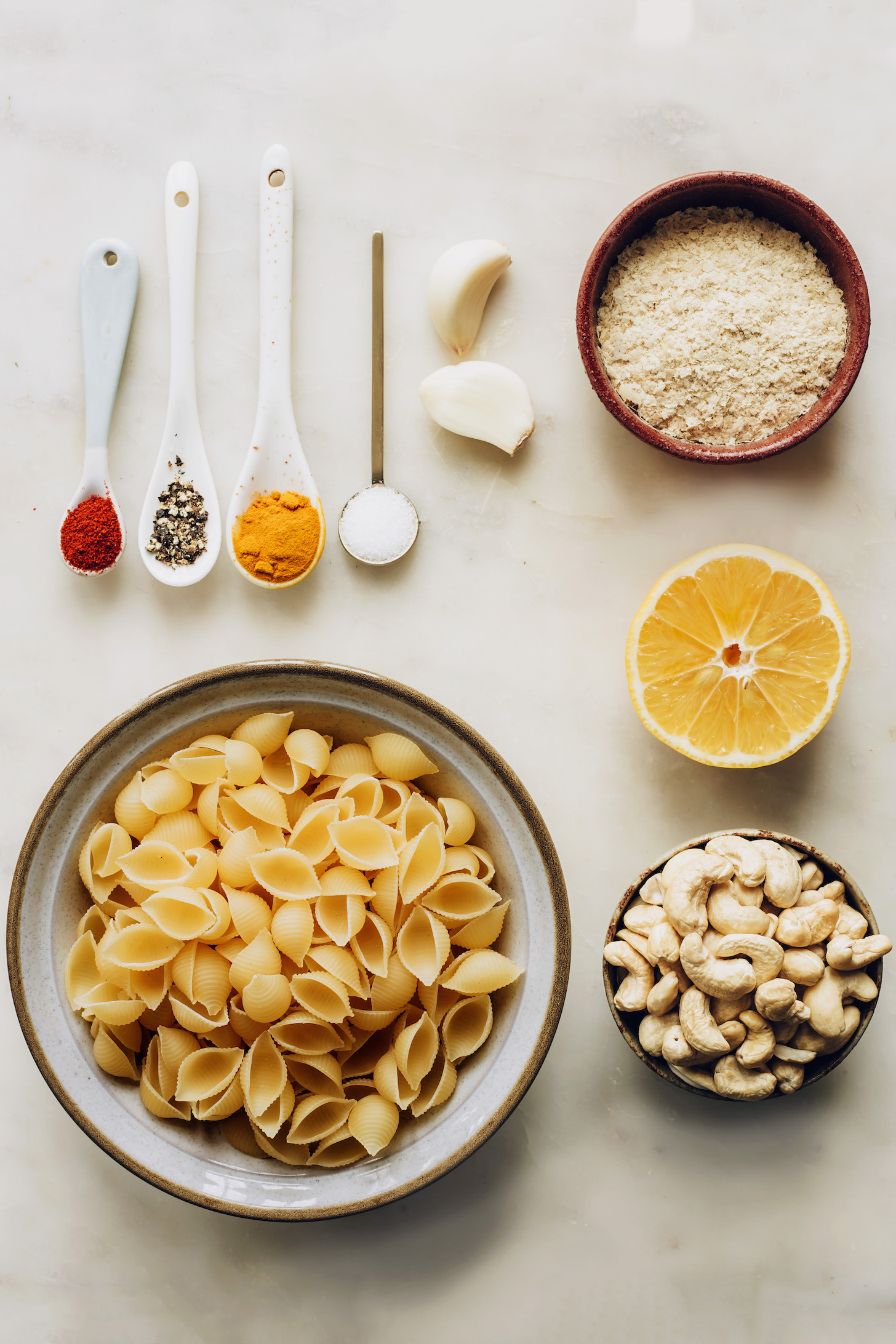 Shell pasta, cashews, lemon, nutritional yeast, salt, garlic, turmeric, pepper, and chili powder