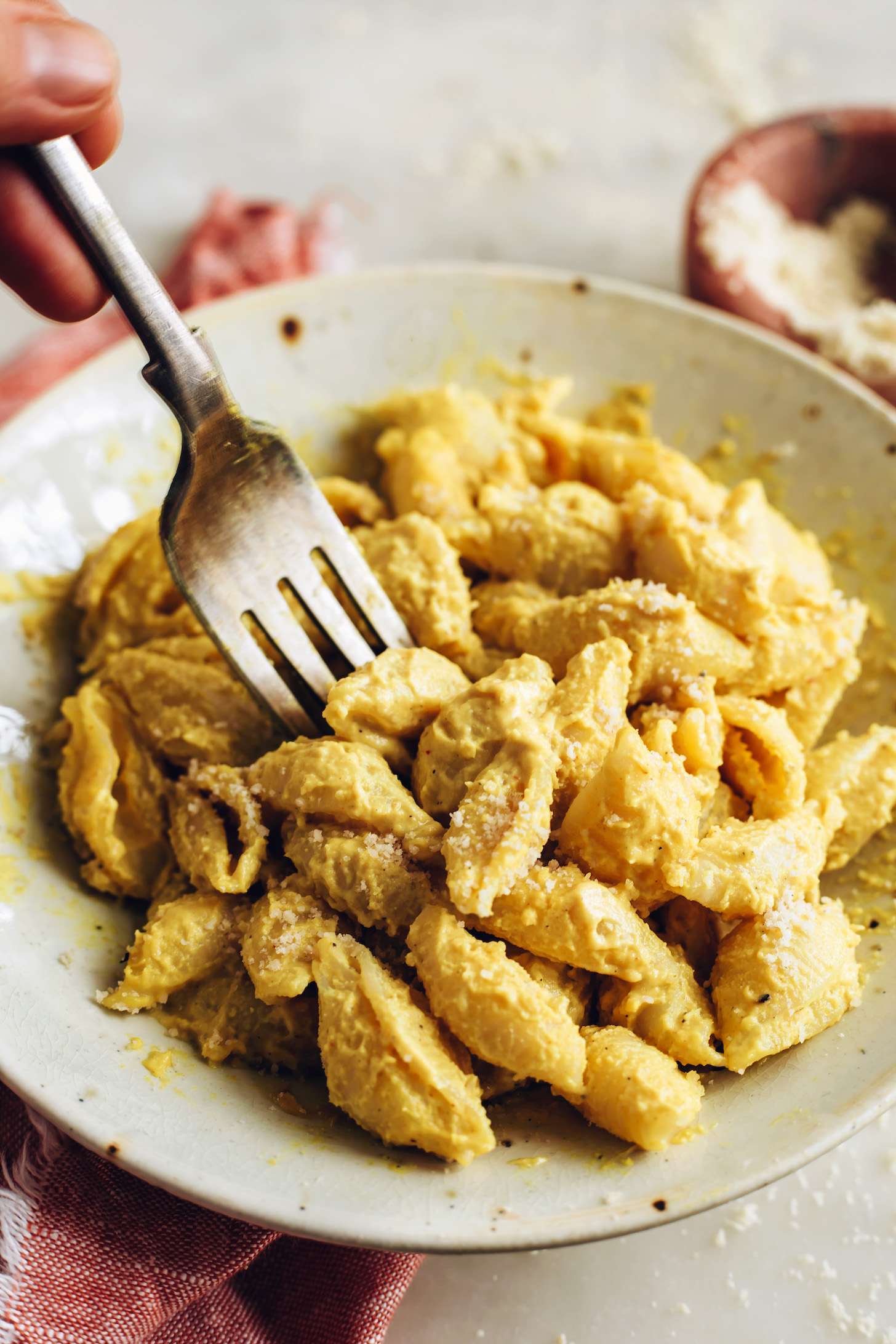 Fork picking up vegan mac and cheese from a bowl
